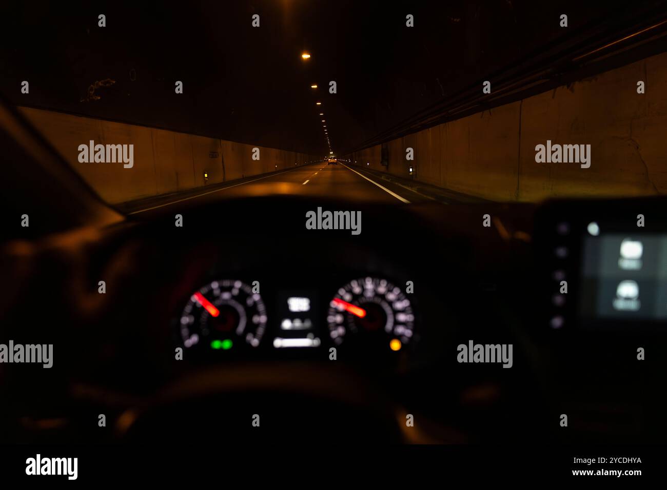 Blick aus dem Inneren eines Autos, das nachts in einem großen Tunnel in gerader Linie fährt. Fahrer-POV, der in einem Tunnel fährt. Stockfoto