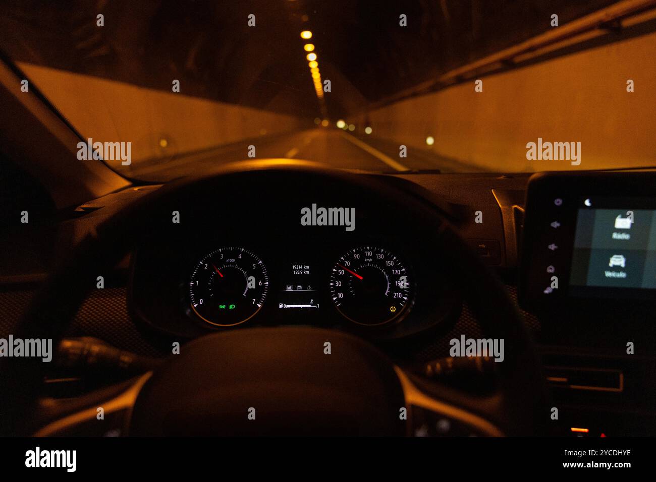 Ansicht des Fahrers zum Tachometer. Unscharfe, leere Tunnelstraße in der Nacht. Insel Madeira, Portugal. Stockfoto