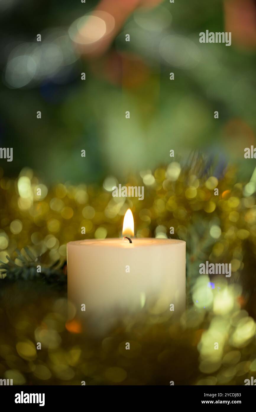 Weiße Chritmas Kerze mit goldenem Lametta und grünem Hintergrund Stockfoto