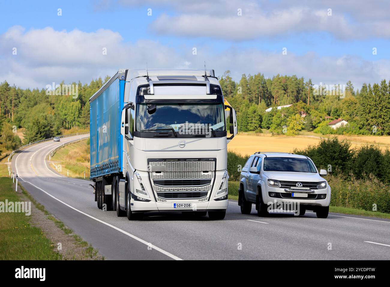 Der weiße Volkswagen Amarock Pickup-Truck überholt einen neuen Volvo FH schweren Lkw-Auflieger auf einspuriger Straße. Salo, Finnland. September 2022. Stockfoto