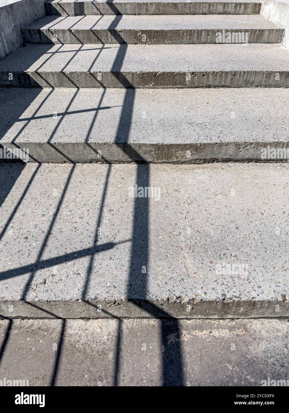 Schatten der Handläufe auf den Betonsteinstufen. Urbane Outdoor-Szene. Stockfoto