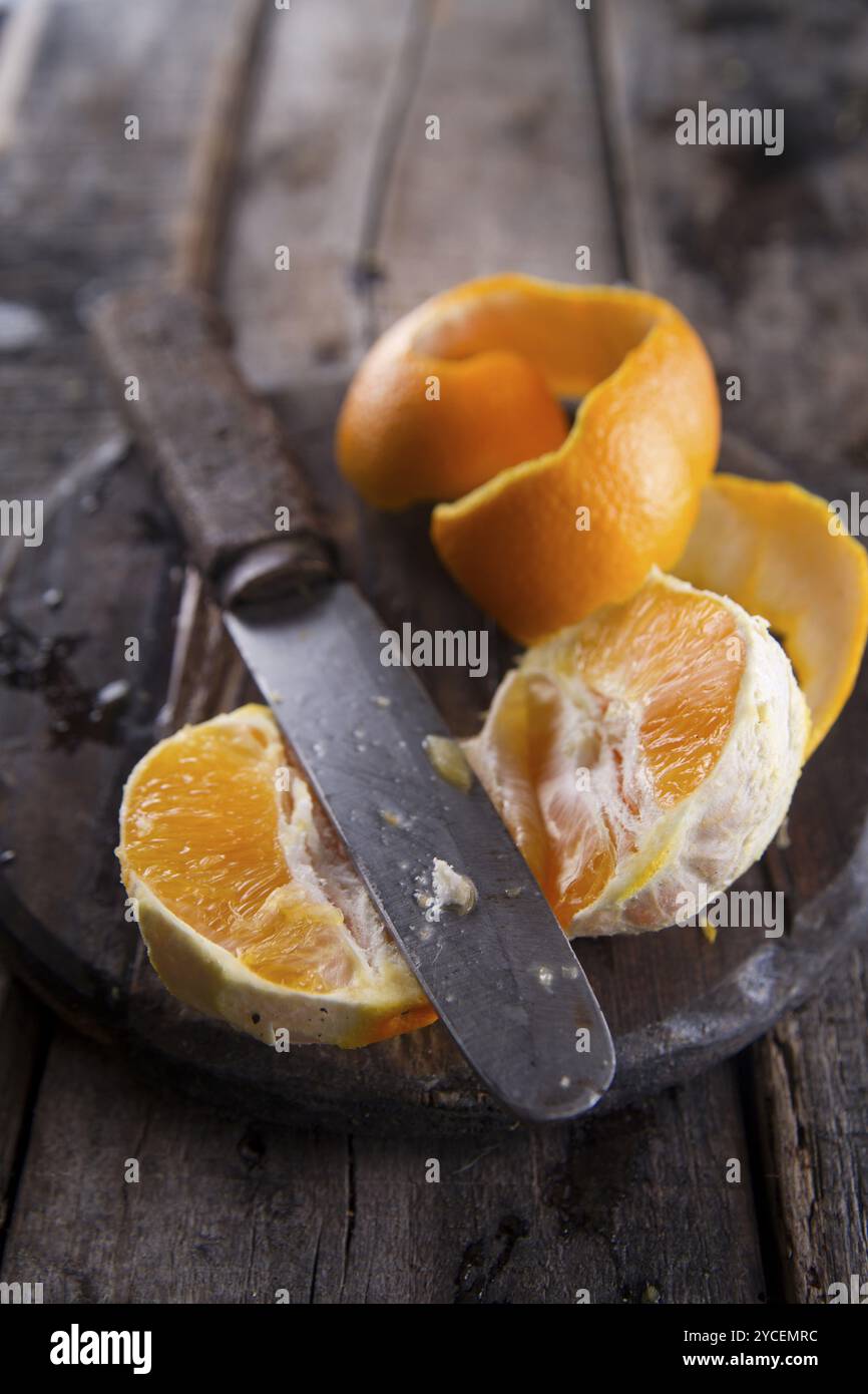 Eine orange mit der Verwendung eines alten Messer auf den Tisch ziehen Stockfoto