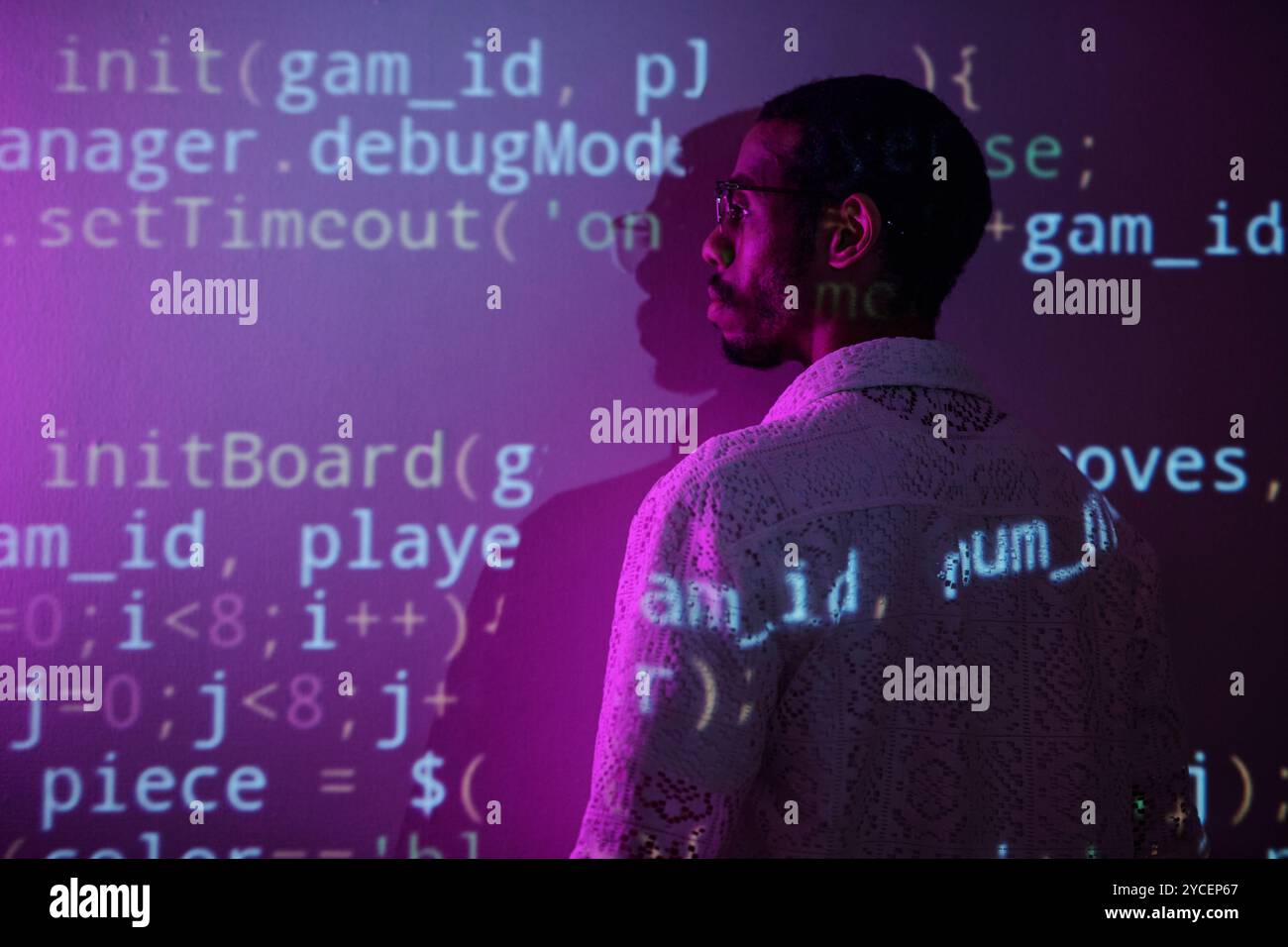 Computercode, der auf der Wand projiziert wird, wird untersucht Stockfoto