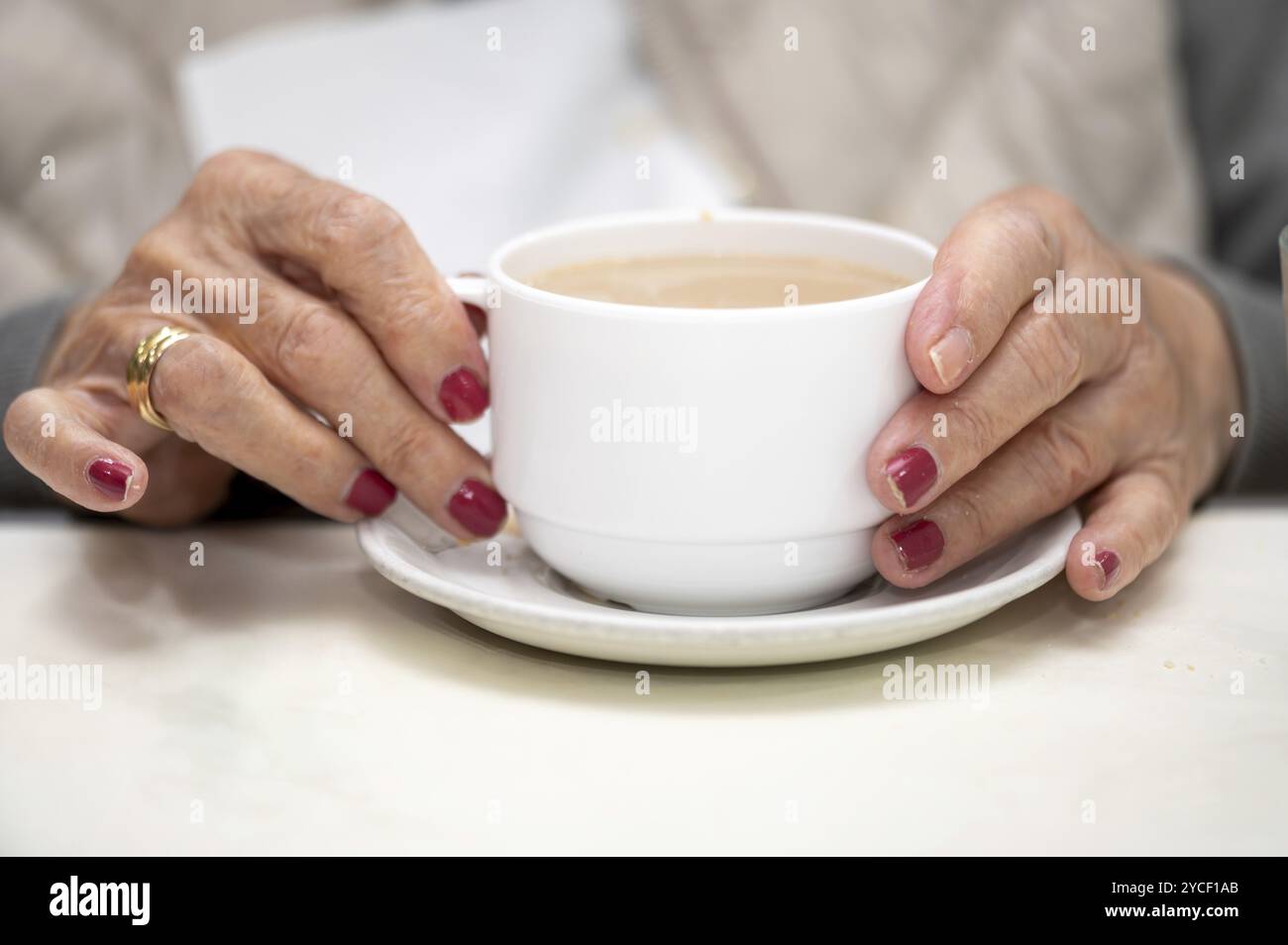 Nahaufnahme einer älteren Frau, die Frühstück genießt. Stockfoto