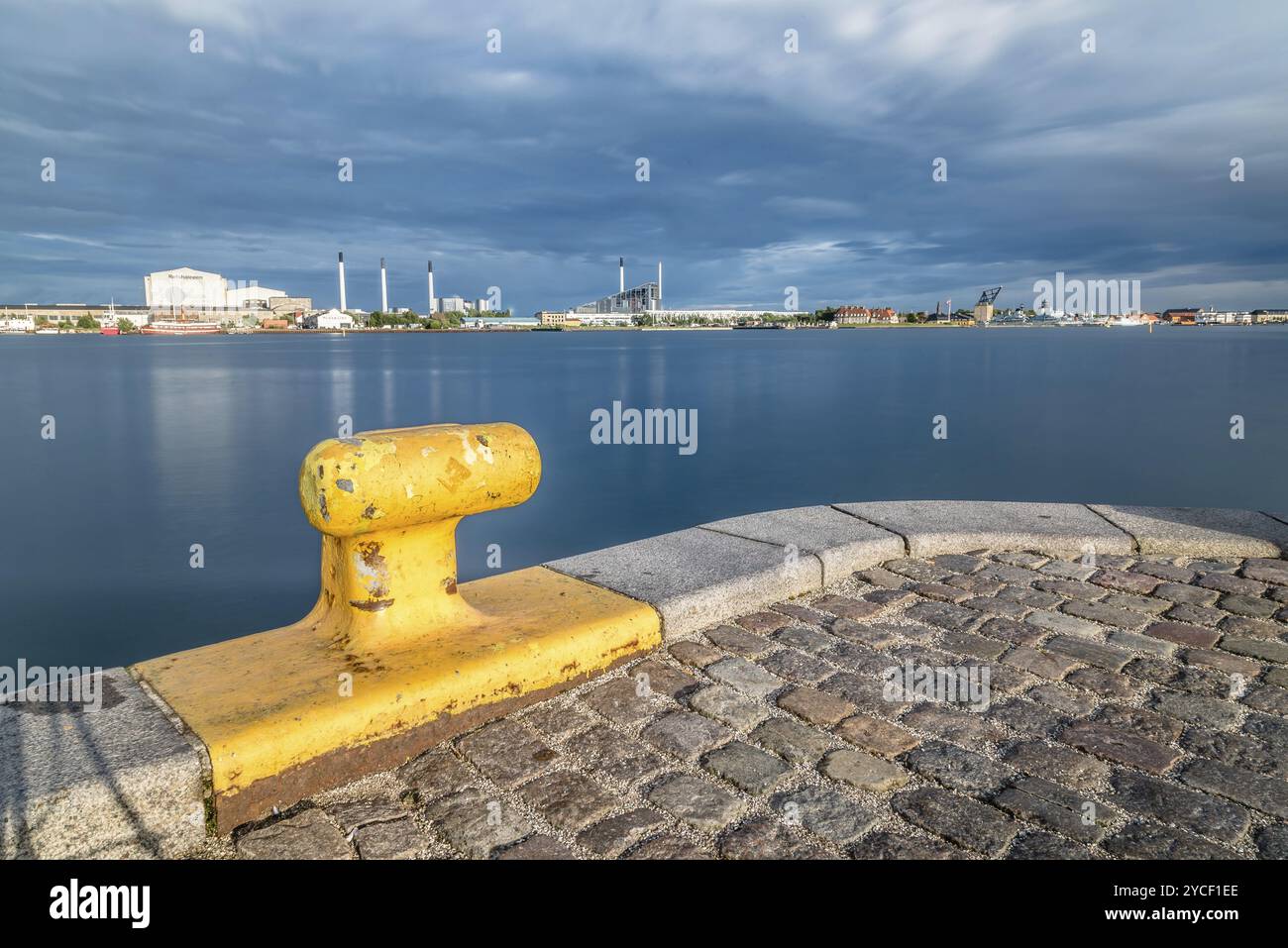 Malerische Aussicht auf die Skyline von Kopenhagen bei Sonnenuntergang vom Dock mit gelben Poller im Vordergrund Stockfoto