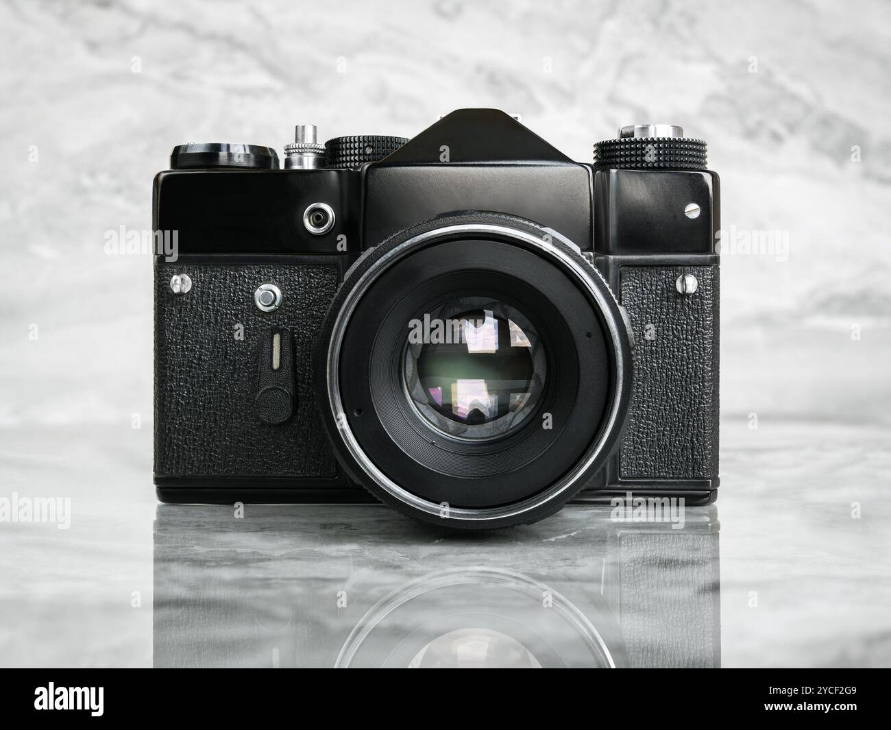 Vorderansicht einer sowjetischen Schwarzfilmkamera auf polierter Marmoroberfläche. Stockfoto