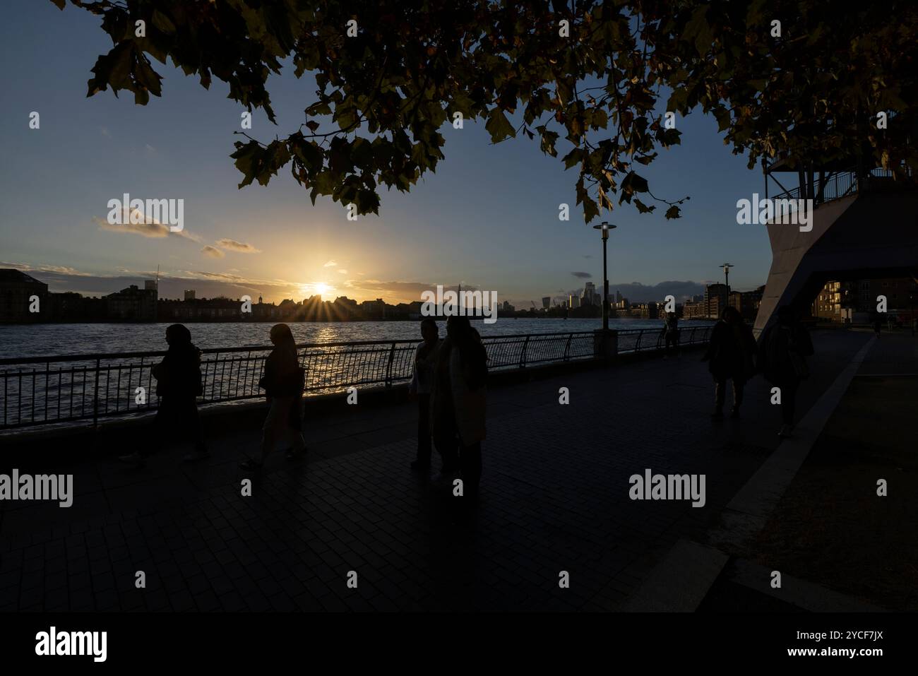 Familienspaziergang bei Sonnenuntergang im Herbst entlang des Flusses Themse Pfade bei Dundee Wharf, Westferry, Docklands, East London, England, UK Stockfoto