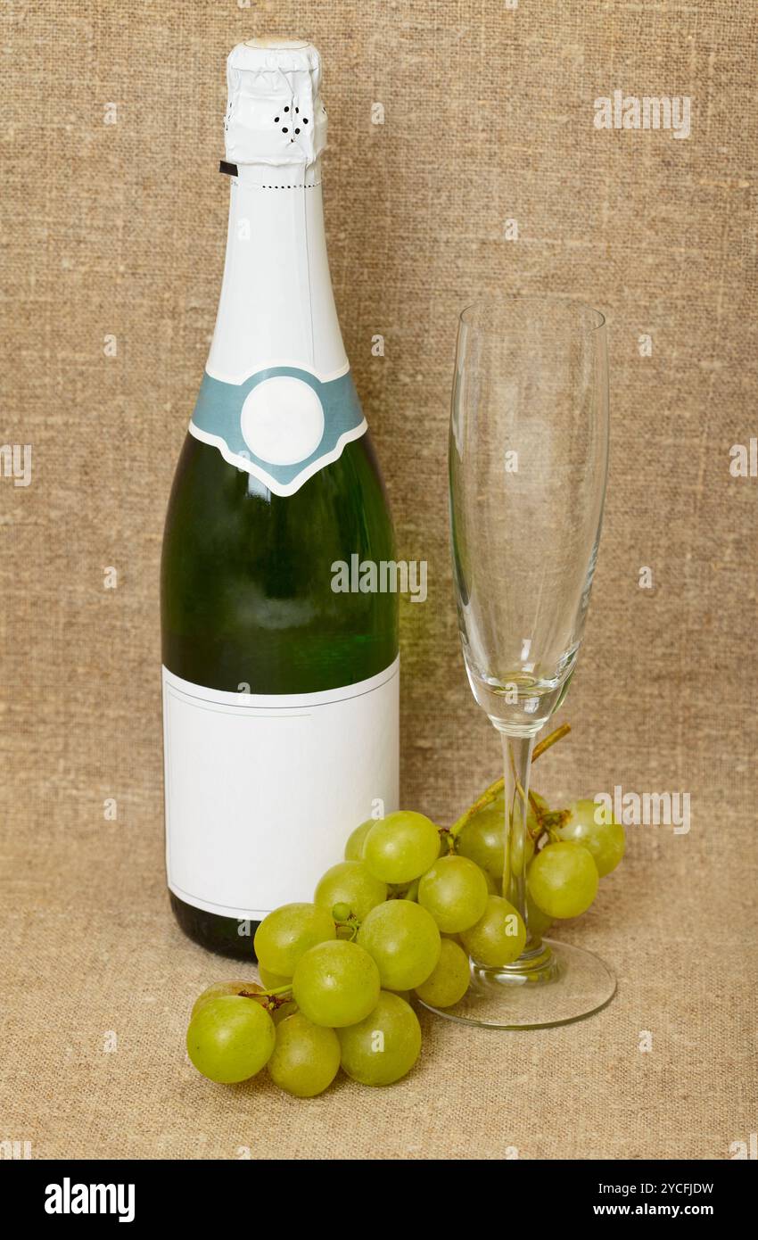 Flasche Sekt, Glas und Trauben auf Leinwand - Stillleben Stockfoto