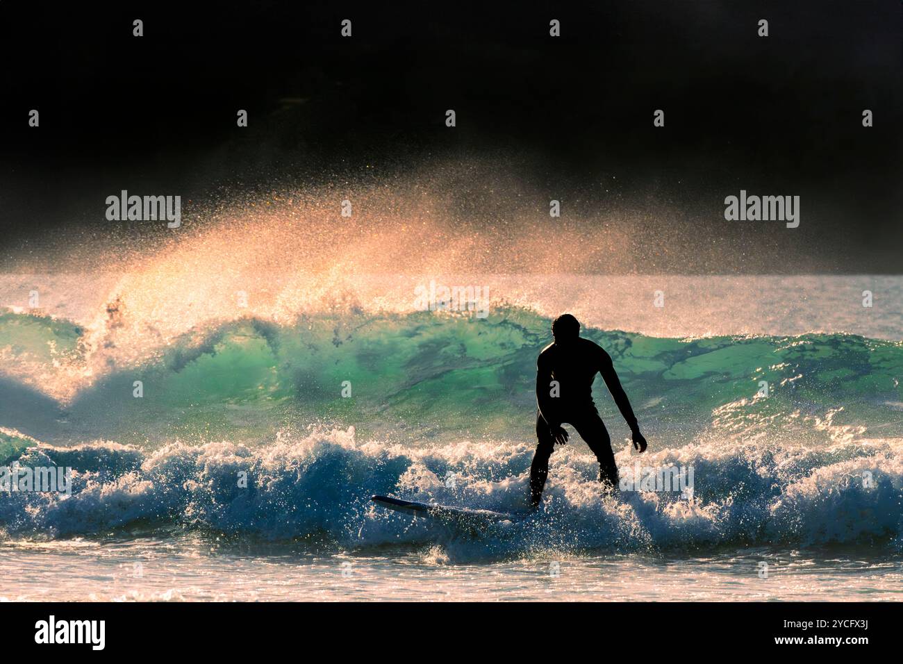 Die Silhouette eines Surfers bei Fistral in Newquay in Cornwall in Großbritannien in Europa Stockfoto