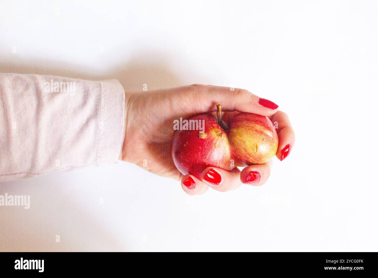 Frau Hand hält Apfel als Konzept für Männerkrankheit oder -Krankheit, Tumor, Unfruchtbarkeit etc. Auf weißem Hintergrund mit Kopierraum Stockfoto