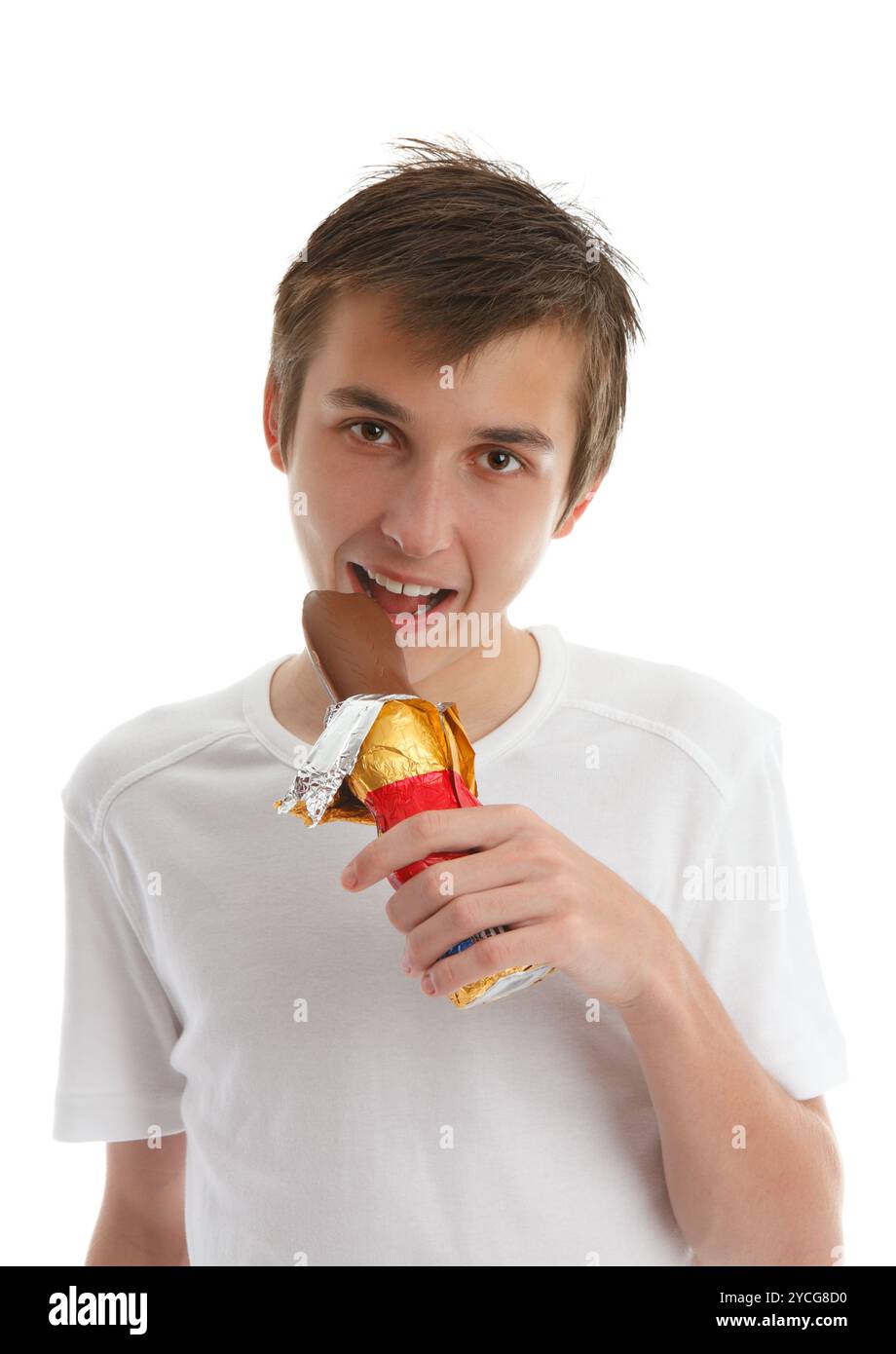 Ein Junge isst einen Milchschokolade-osterhasen. Weißer Hintergrund. Stockfoto