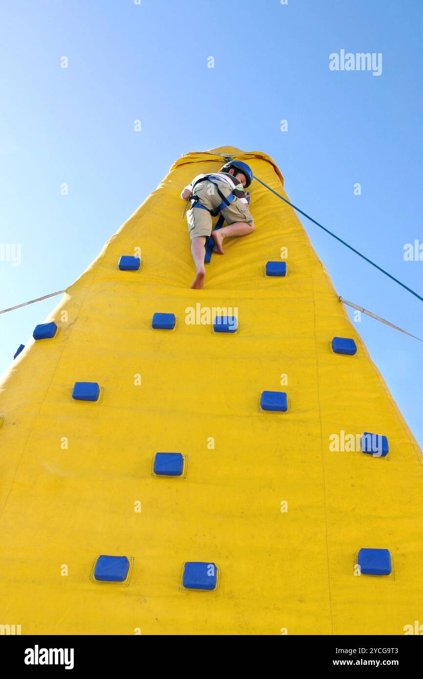 Kind, das von der Kletterwand im Freien herunterkommt Stockfoto