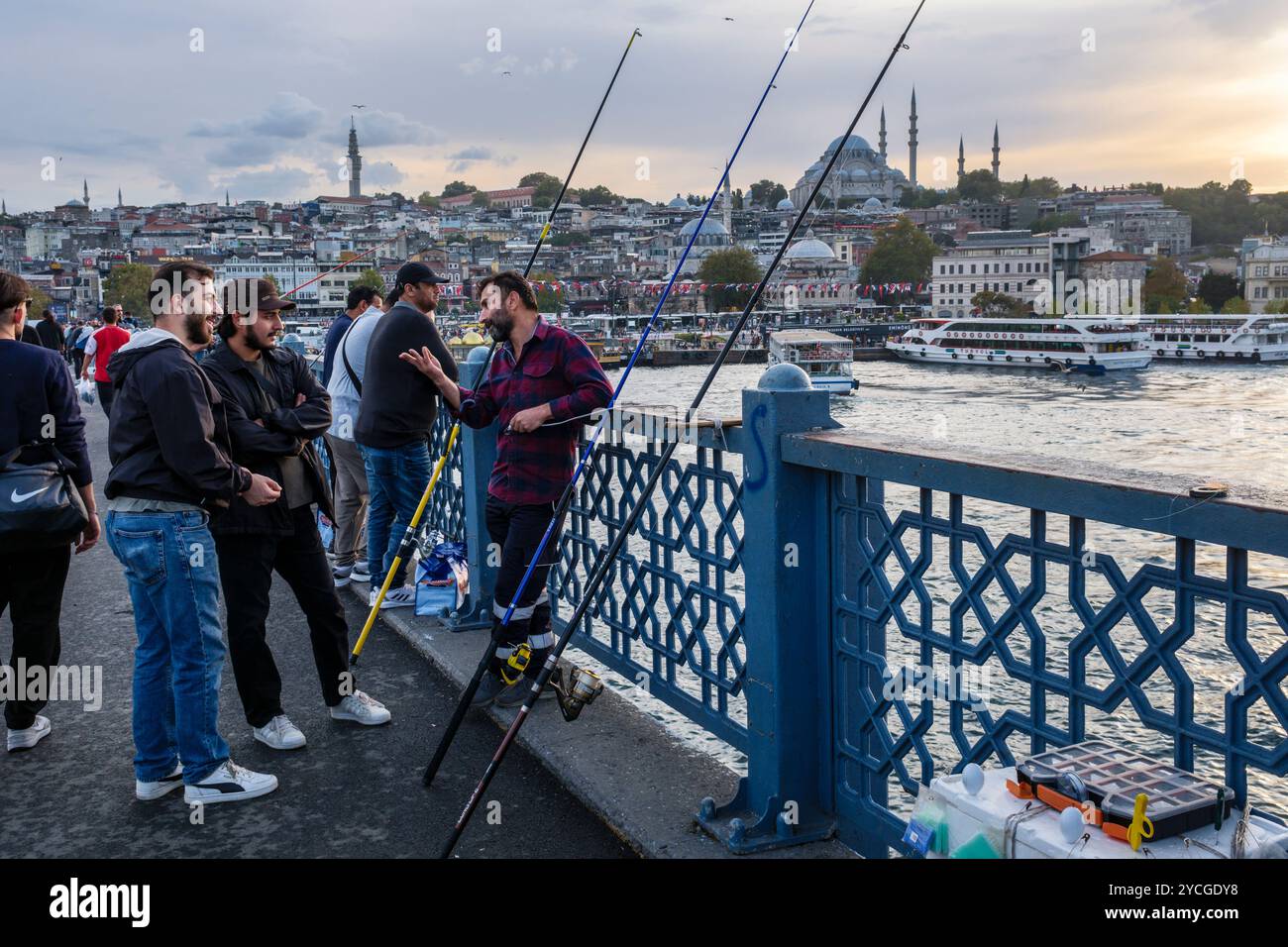 Männer fischen auf der Galata-Brücke bei Sonnenuntergang mit der Süleymaniye-Moschee im Hintergrund, Istanbul, Türkei Stockfoto