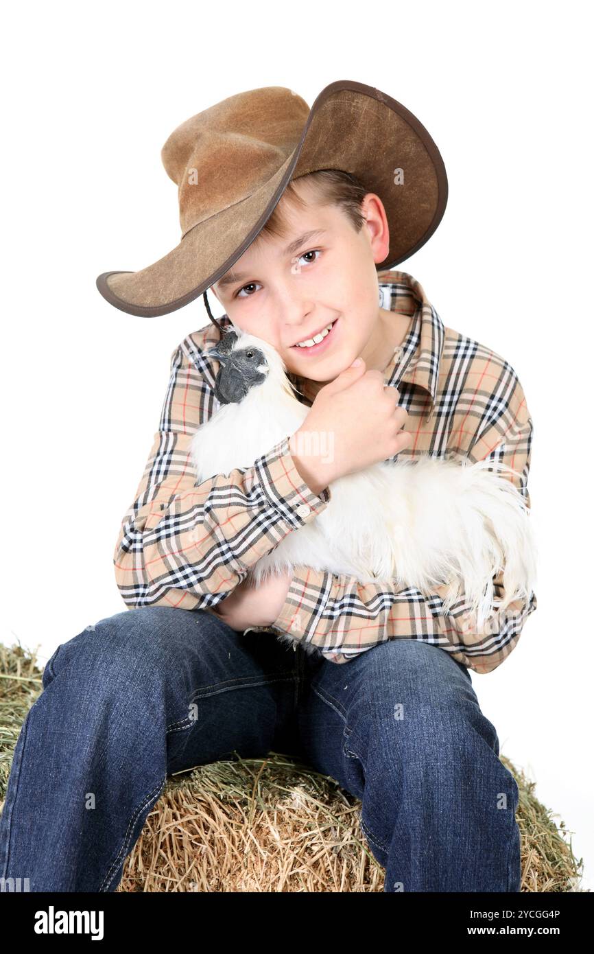 Bauernjunge hält ein Huhn Stockfoto