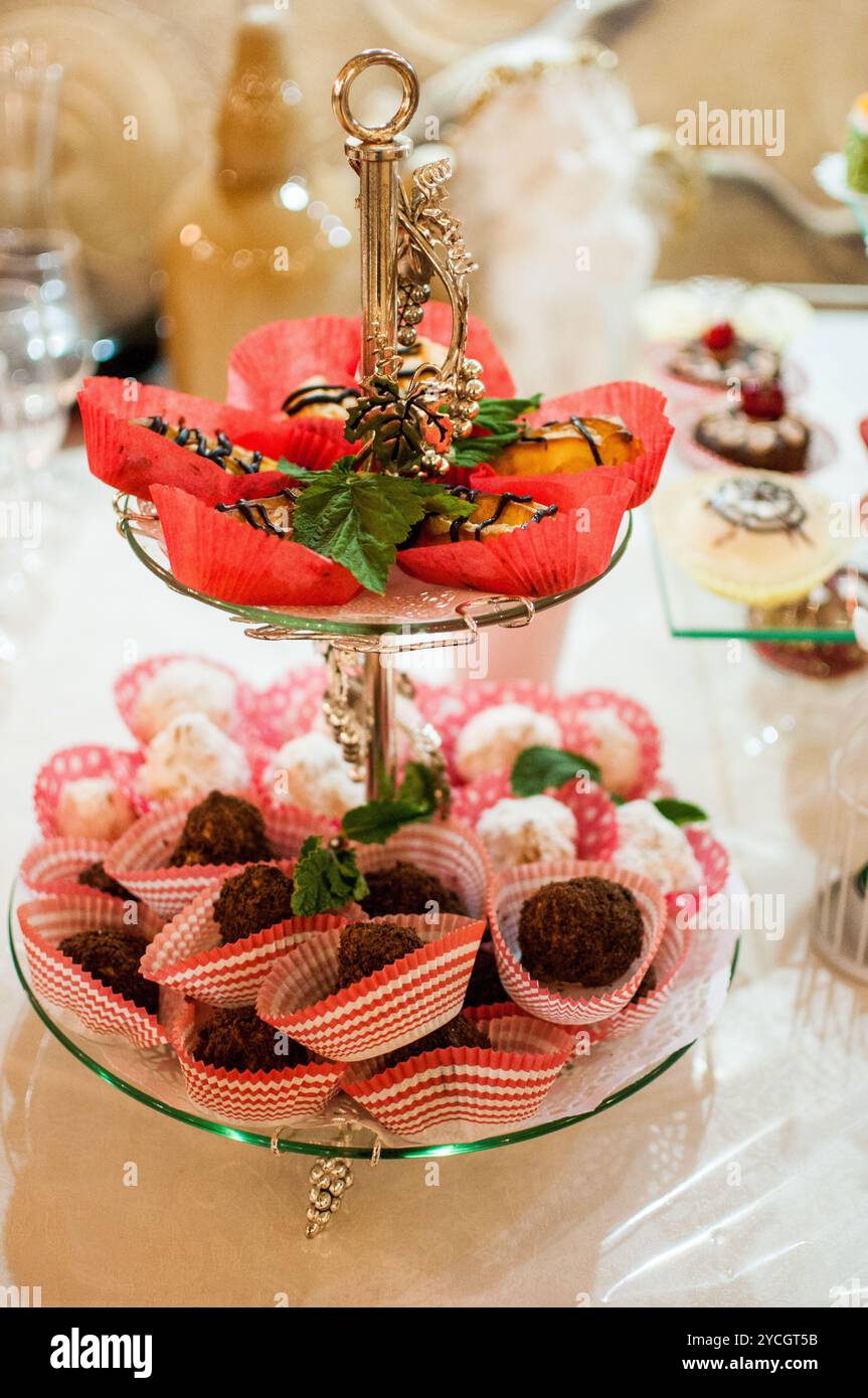 Elegante Dessertpräsentation mit verschiedenen Leckereien und Dekorationen. Stockfoto