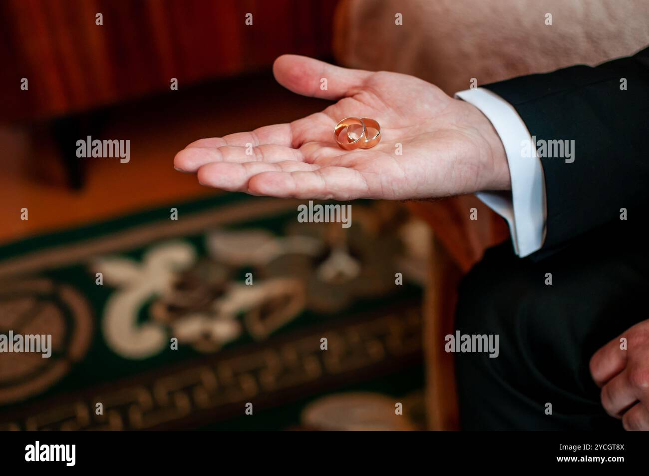 Ein romantischer Moment: Hochzeitsringe ruhen auf einer Hand, die für die Vereinigung vorbereitet ist. Stockfoto