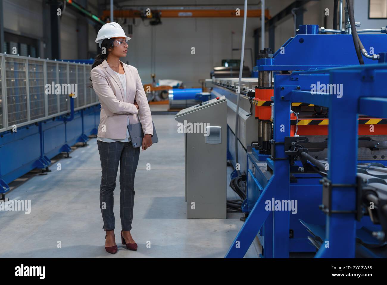 Indianerin, Betriebsleiterin, die den Produktionsprozess und die Industriemaschinen überwacht. Industrie-, Personal- und Automatisierungskonzepte. Stockfoto