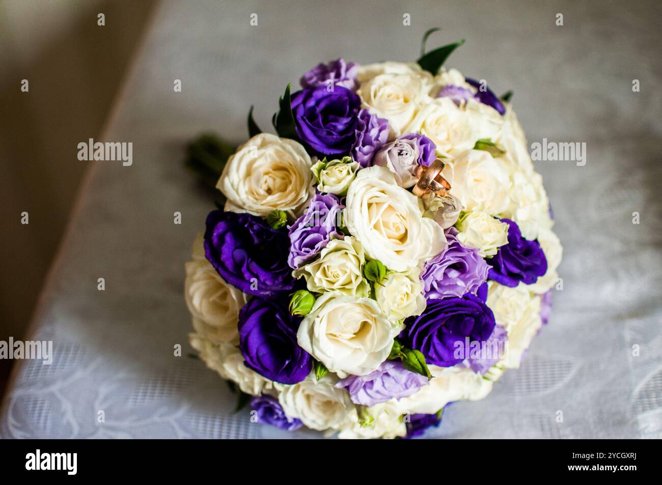 Elegant gestalteter Blumenstrauß aus weißen und lila Rosen. Stockfoto
