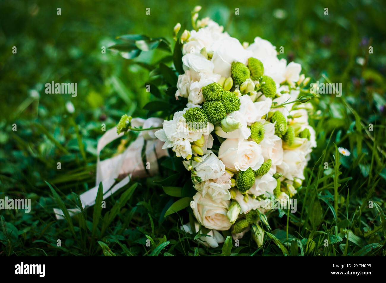 Eleganter Blumenstrauß mit grünen Akzenten im üppigen Gras. Stockfoto