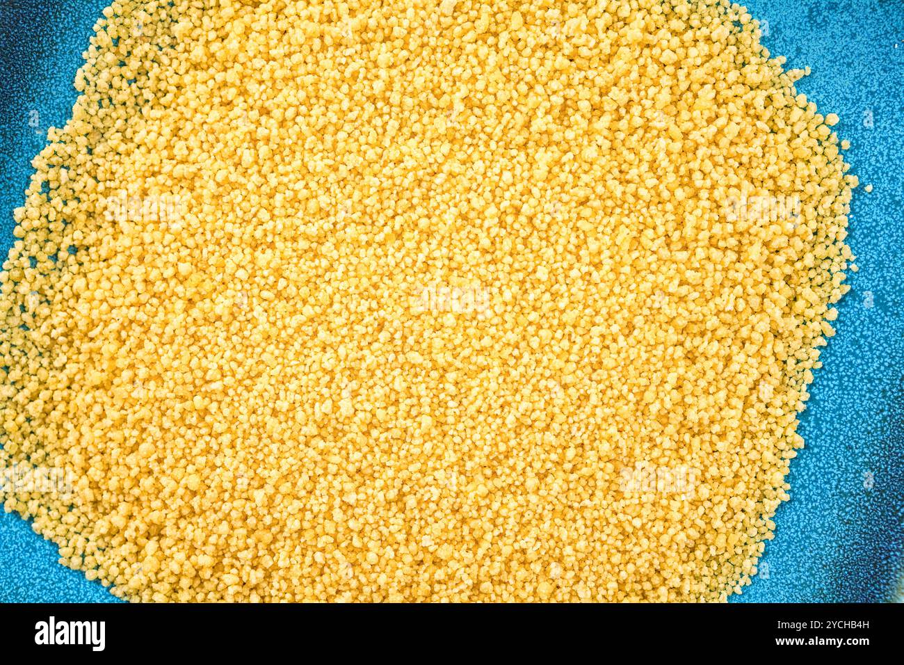 Roher Couscous auf einem blauen Teller. Stockfoto