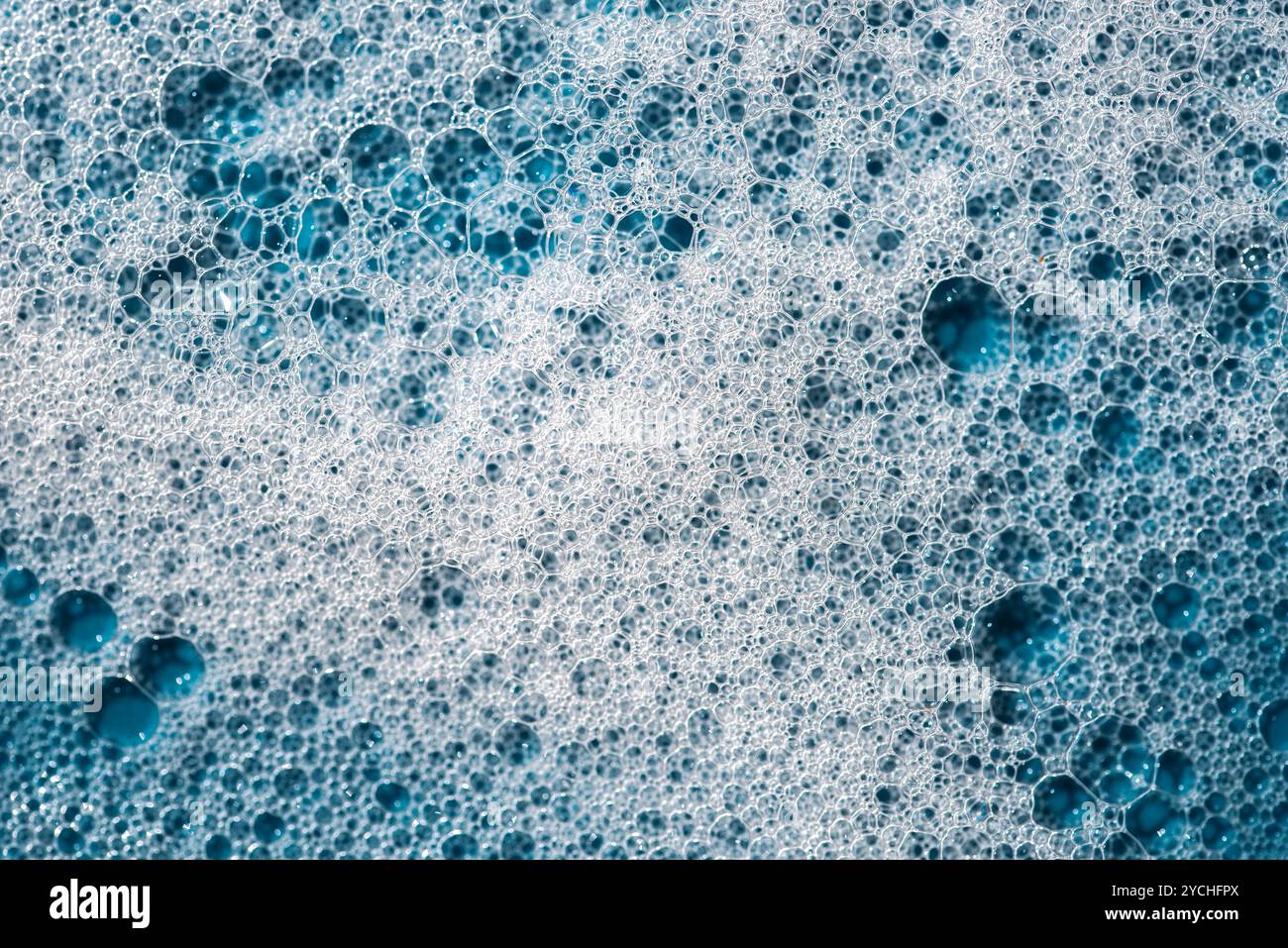 Hintergrund und Muster. Weißer Seifenschaum mit Blasen, Textur auf blauem Fliesenhintergrund. Reinigungsmittelschaumblase auf Fliesen. Duschgel, Haarshampoo Schaum sm Stockfoto