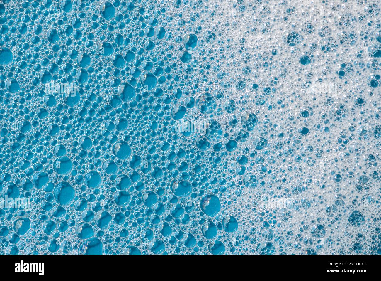 Hintergrund und Muster. Weißer Seifenschaum mit Blasen, Textur auf blauem Fliesenhintergrund. Reinigungsmittelschaumblase auf Fliesen. Duschgel, Haarshampoo Schaum sm Stockfoto