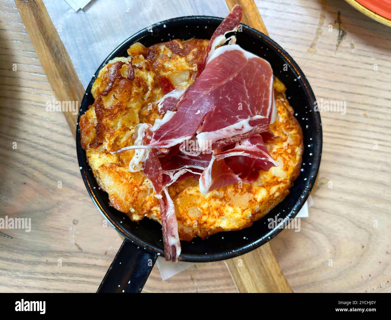 Spanisches Omelett mit iberischem Schinken. Spanien. - Smartphone-aufgenommenes Stockfoto