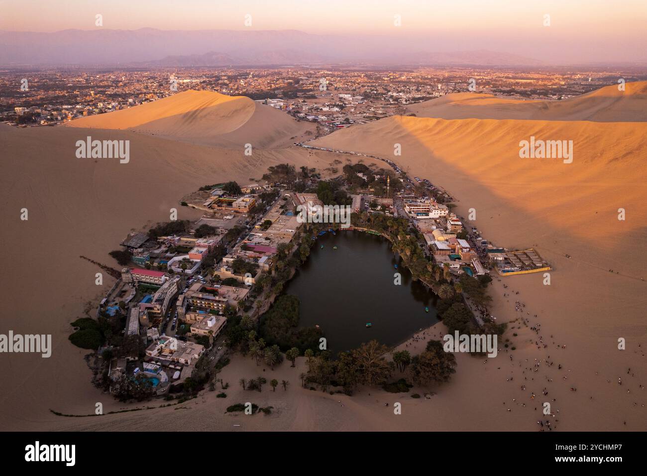 Traumhafte Oase-Stadt mitten in den großen Wüstendünen, bekannt als Huacachina nahe Ica, Peru bei Sonnenuntergang Stockfoto