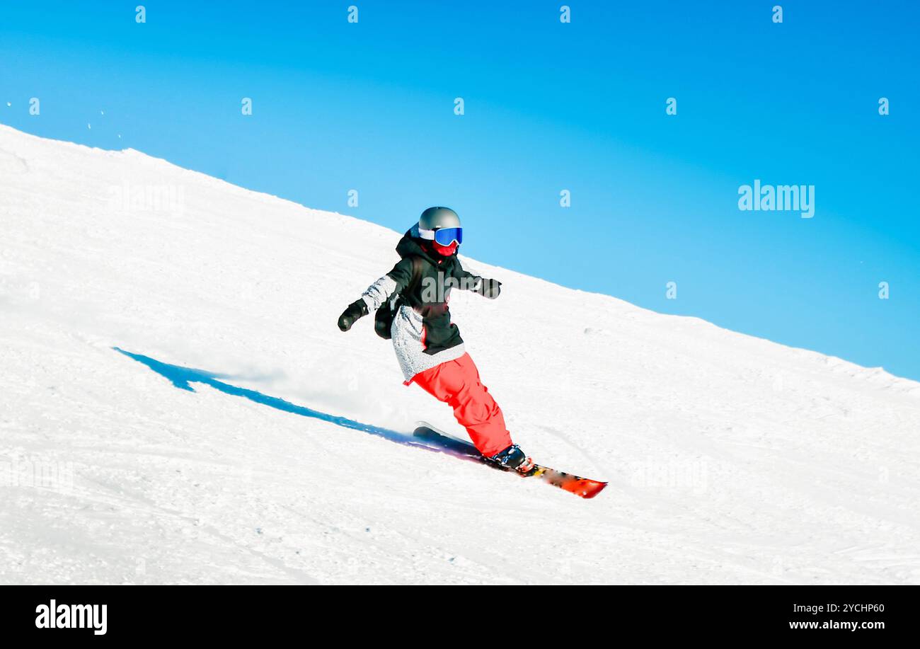 Dynamisches Bild der Frau Skierfahrer tragen schwarz rot Wintersportbekleidung isoliert auf der Piste Ski Downhill schnelle Bewegung in den Alpen. Aktive Winterferien, Skifahren dow Stockfoto