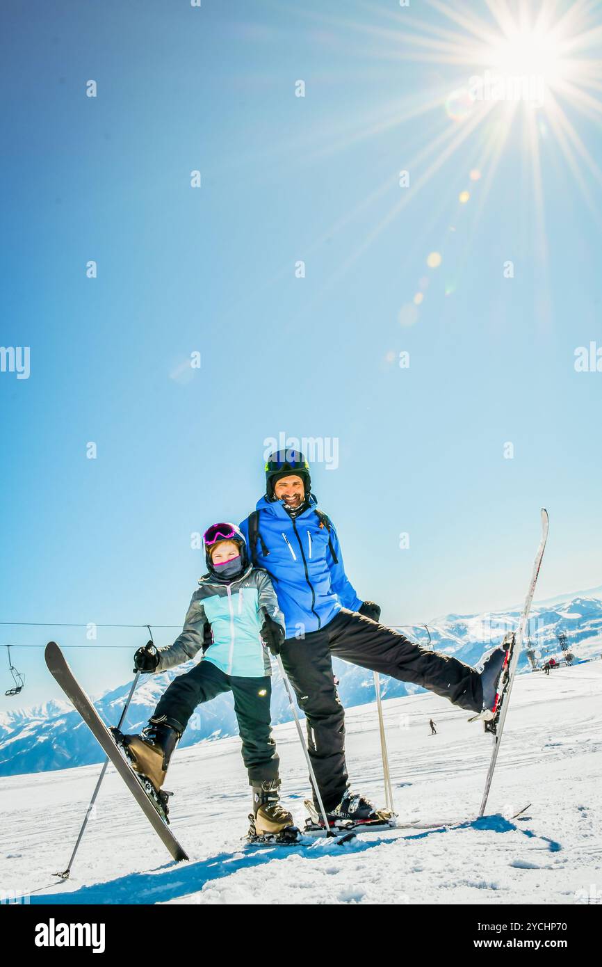 Skifahrer-Familie, die Winterurlaub auf Schnee an sonnigen kalten Tagen in den Bergen und Spaß genießt. Zwei Skifahrer, männlich und weiblich, posieren zusammen mit Skiern im Freien Stockfoto
