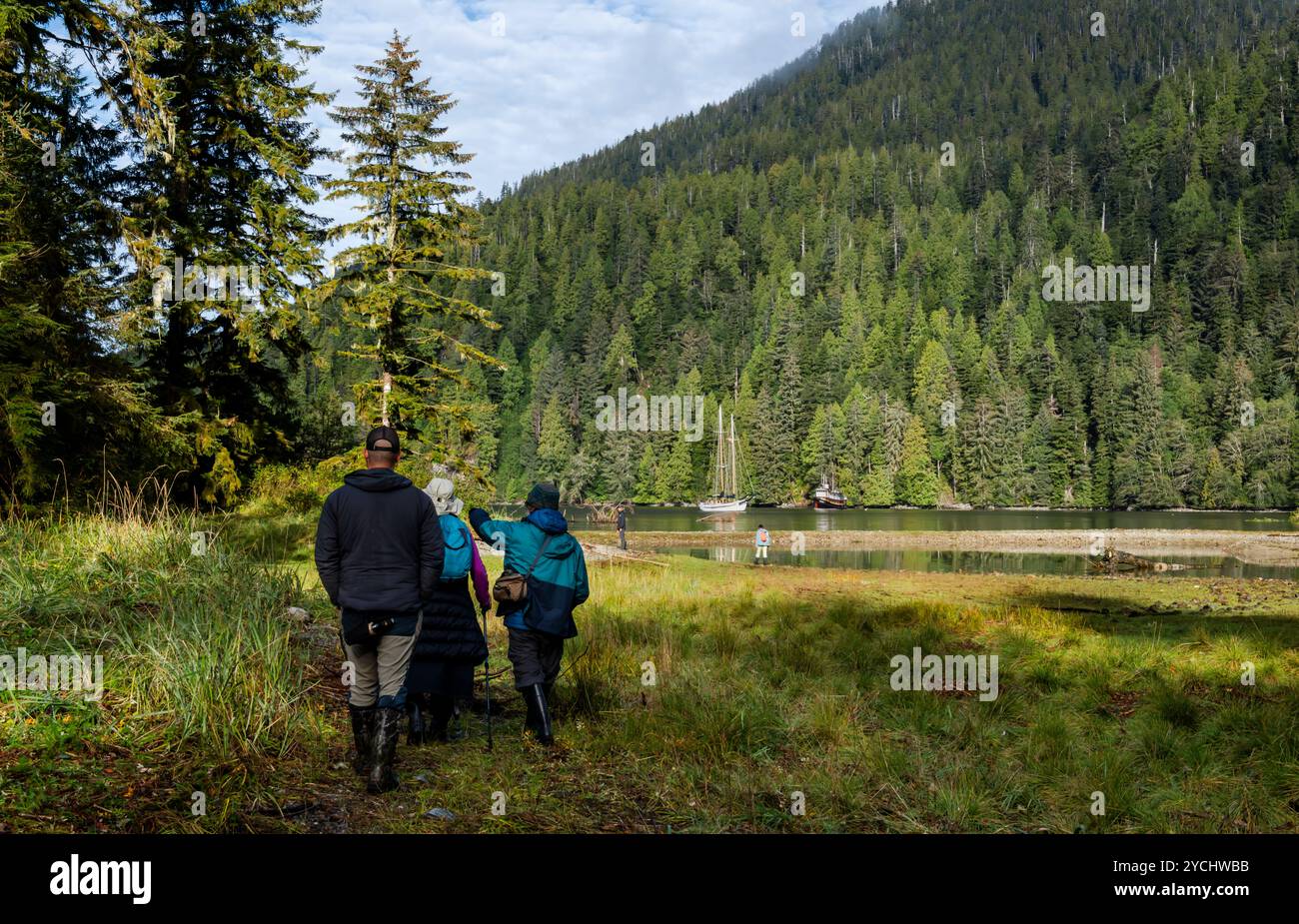 Eine Gruppe von Ökotourismus-Wanderern und Senioren, geführt von einem Reiseleiter, erkunden den Küstenlebensraum des Great Bear Rain Forest in British Columbia, Kanada. Stockfoto