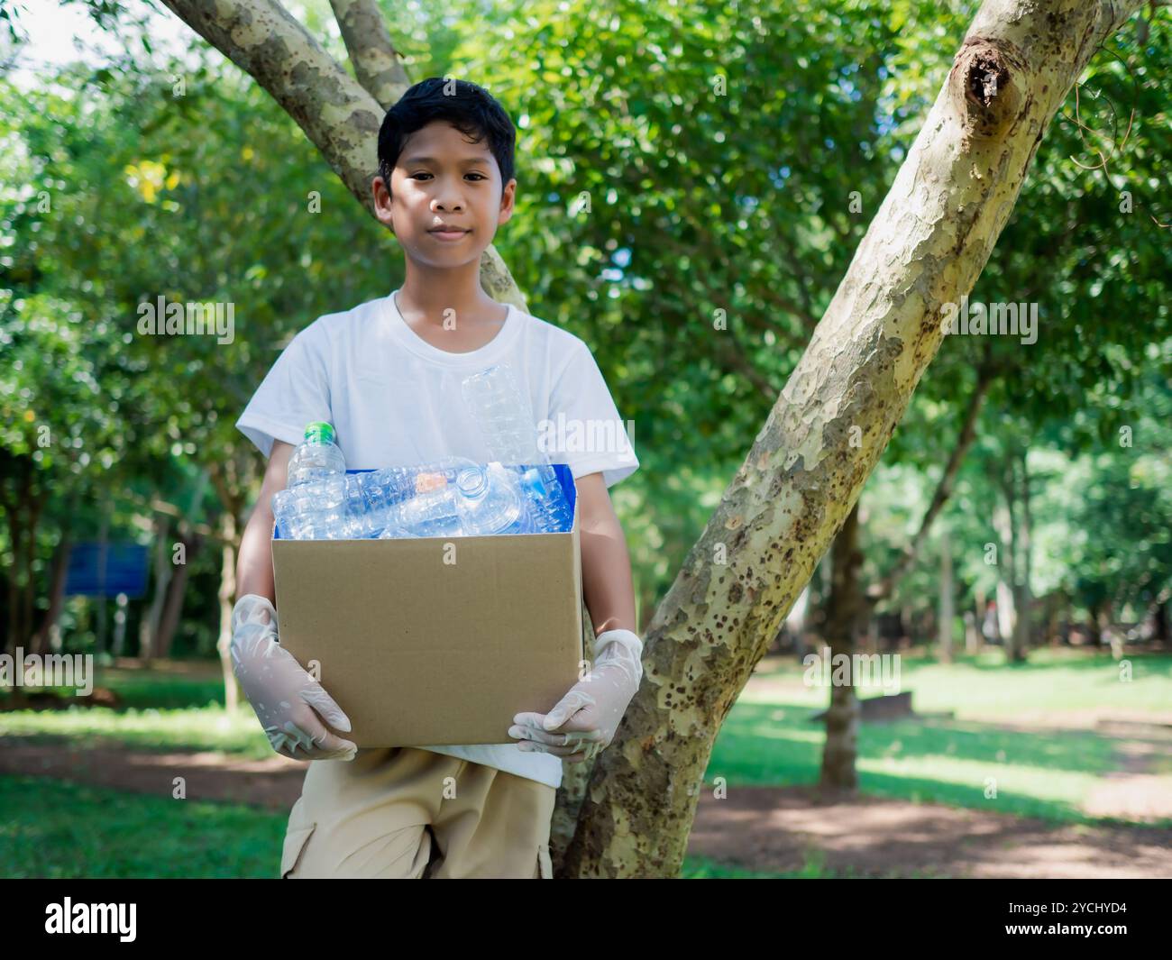 Reduzierung der Umweltverschmutzung und Recycling-Konzept, Kunststofffrei, Junk Food Kunststoffverpackung. Boy hält Kartons zum Recycling und hält einen Stockfoto