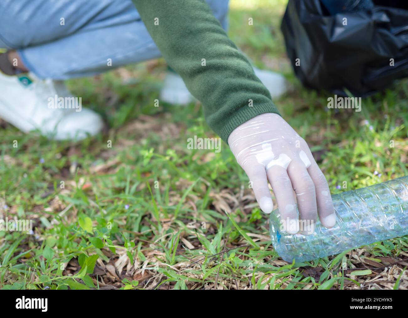 Frauen engagierter Freiwilliger nehmen an einer Umweltreinigungsaktion in einem Park Teil. Frau trägt Handschuhe und hält große schwarze Taschen. Frau Stockfoto
