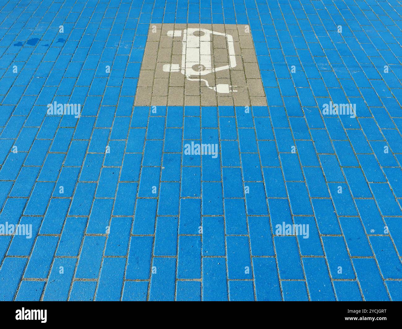 Die auffällige blaue Ladezone mit dem Elektroauto-Symbol markiert den Weg zu einer emissionsfreien Zukunft einer modernen Stadtplanung und nachhaltigen Mobilität Stockfoto