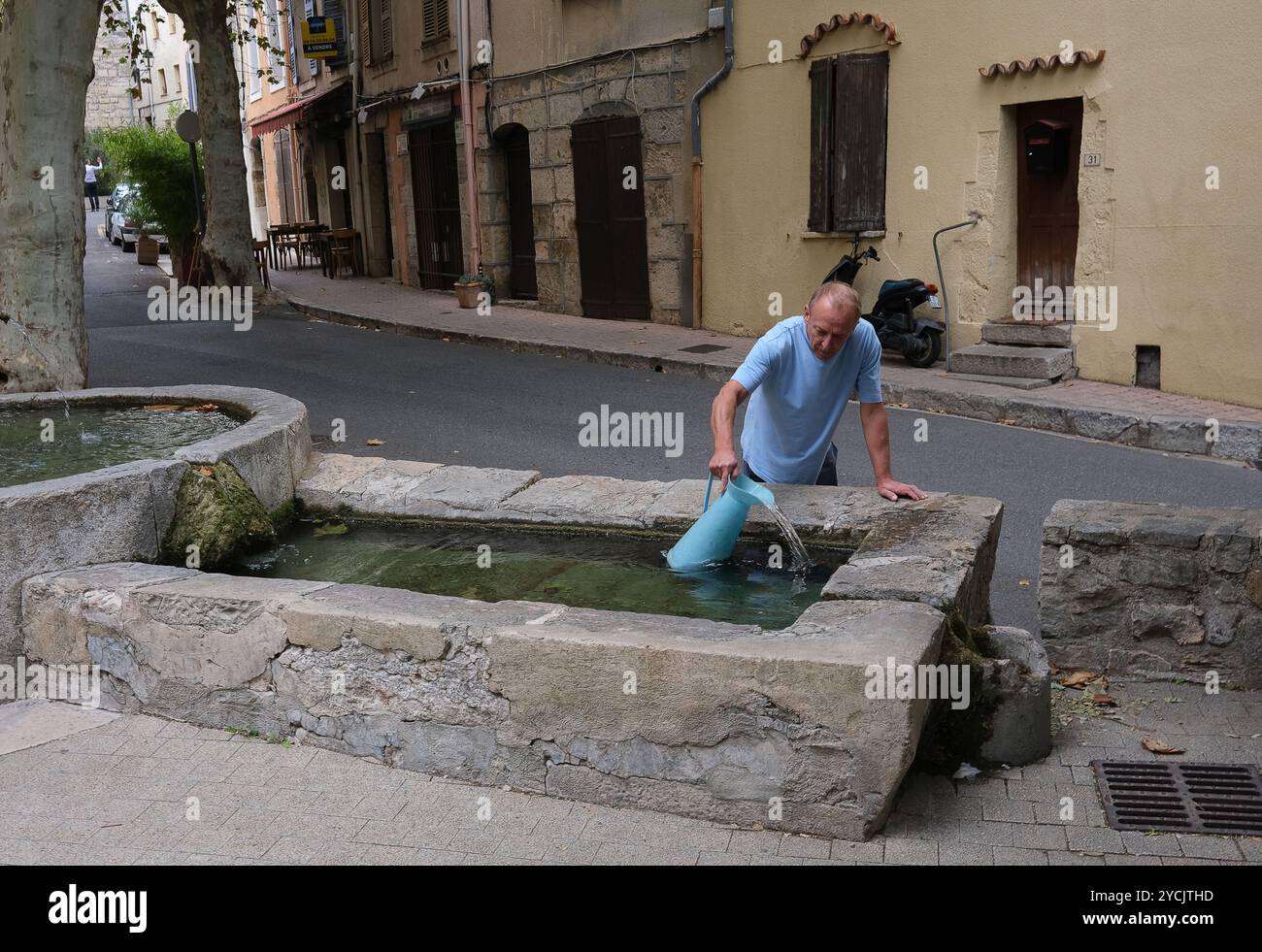Man sammelt Wasser aus einem der vielen Brunnen im französischen Dorf Bargemon im Departement Var in der Provence-Alpes-Côte d'Azur Stockfoto