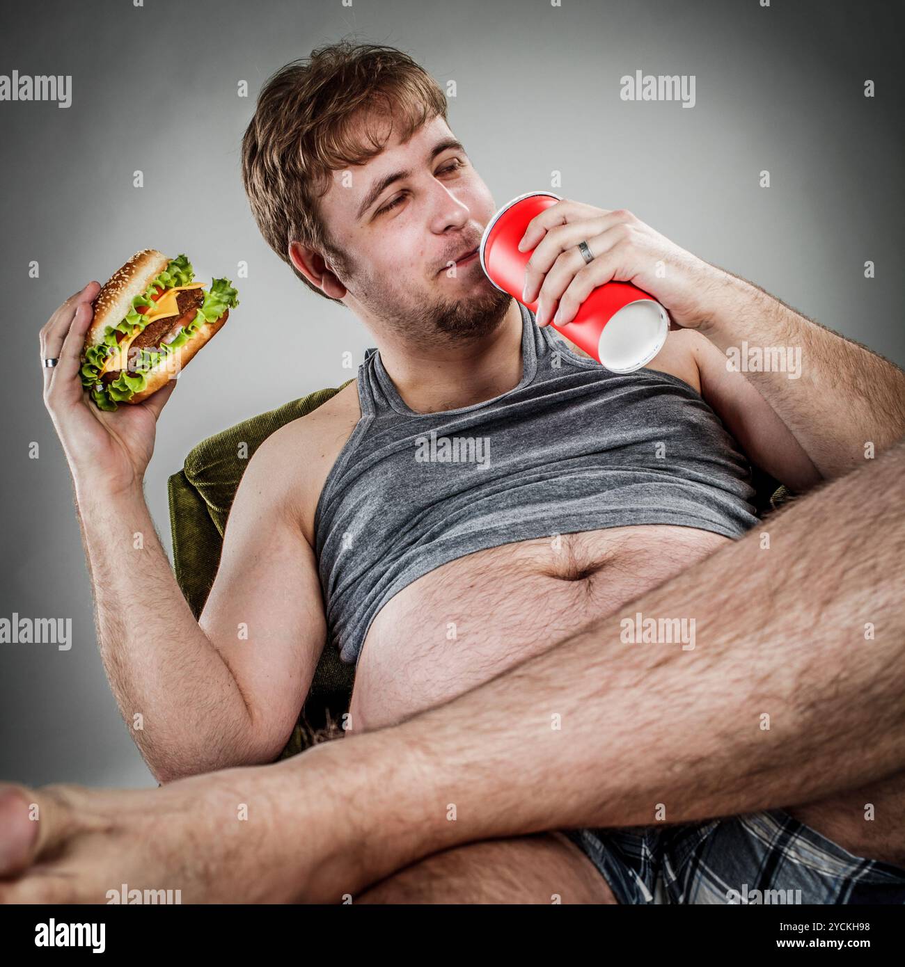 Fetter Mann, der Hamburger isst Stockfoto