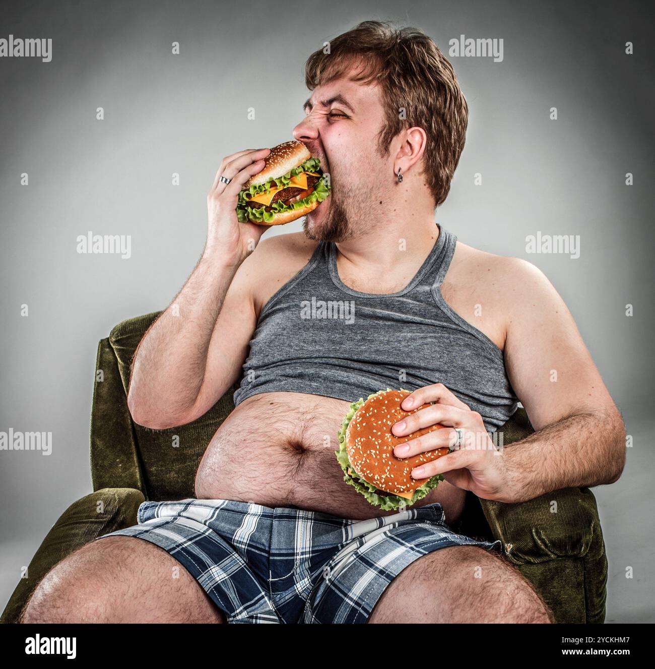 Fetter Mann, der Hamburger isst Stockfoto