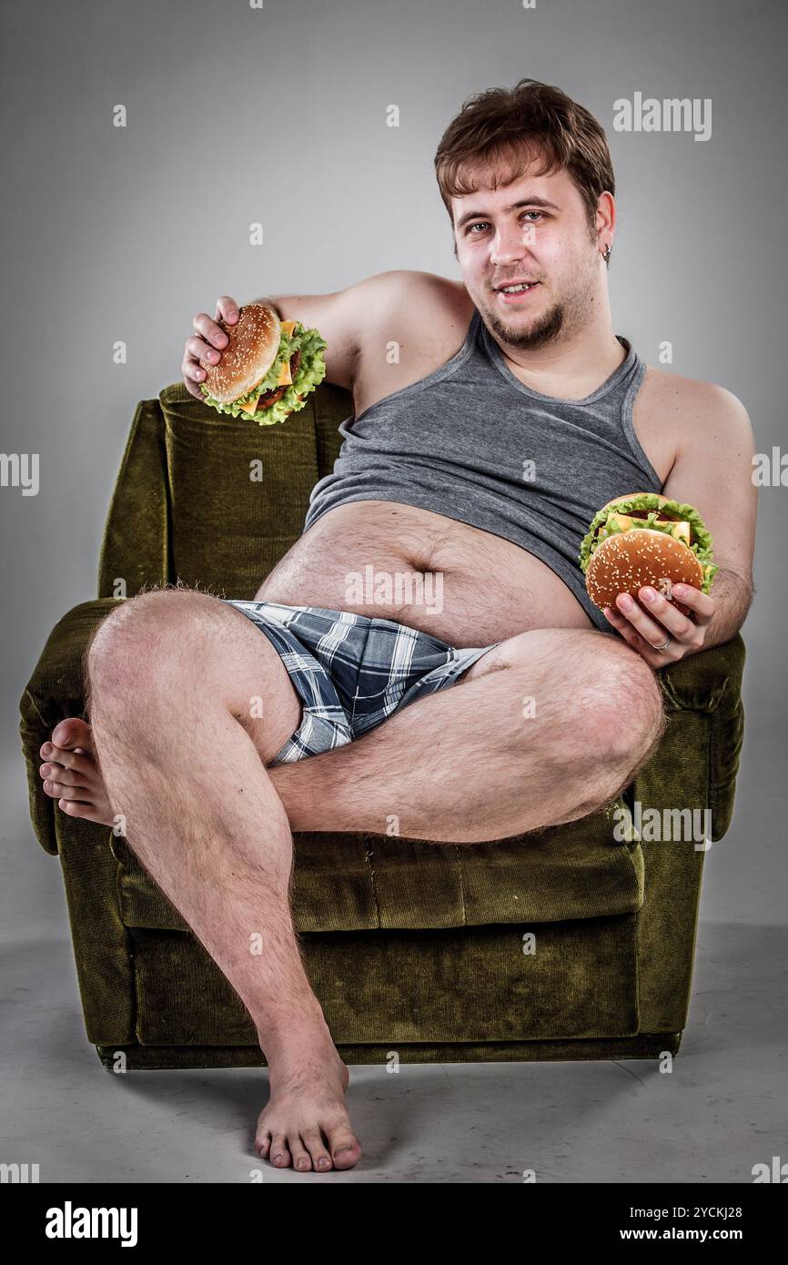 Fetter Mann, der Hamburger isst Stockfoto