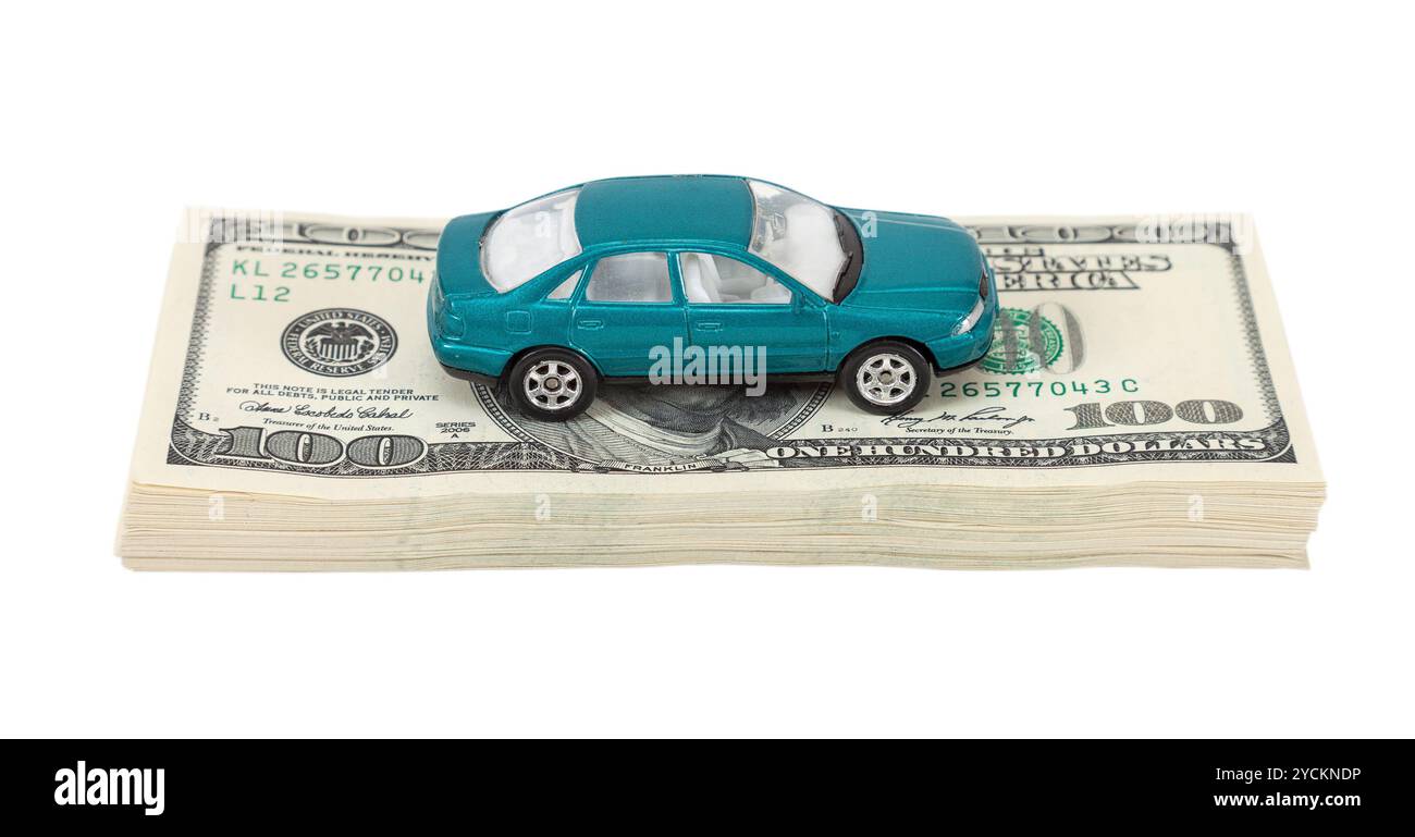 Spielzeugauto auf dem Stapel Dollarscheine isoliert auf weißem Hintergrund Stockfoto