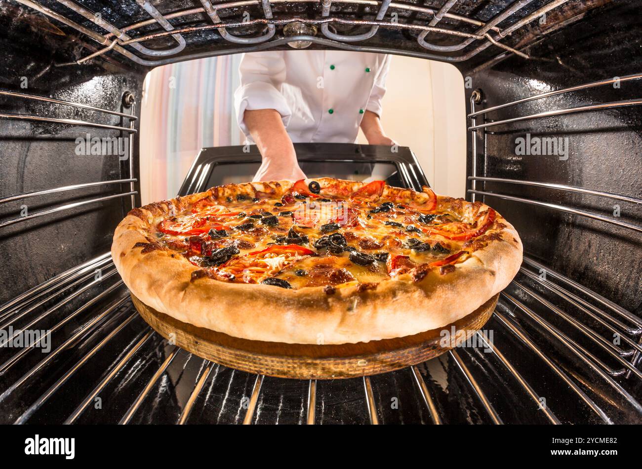 Koch kocht Pizza im Ofen. Stockfoto