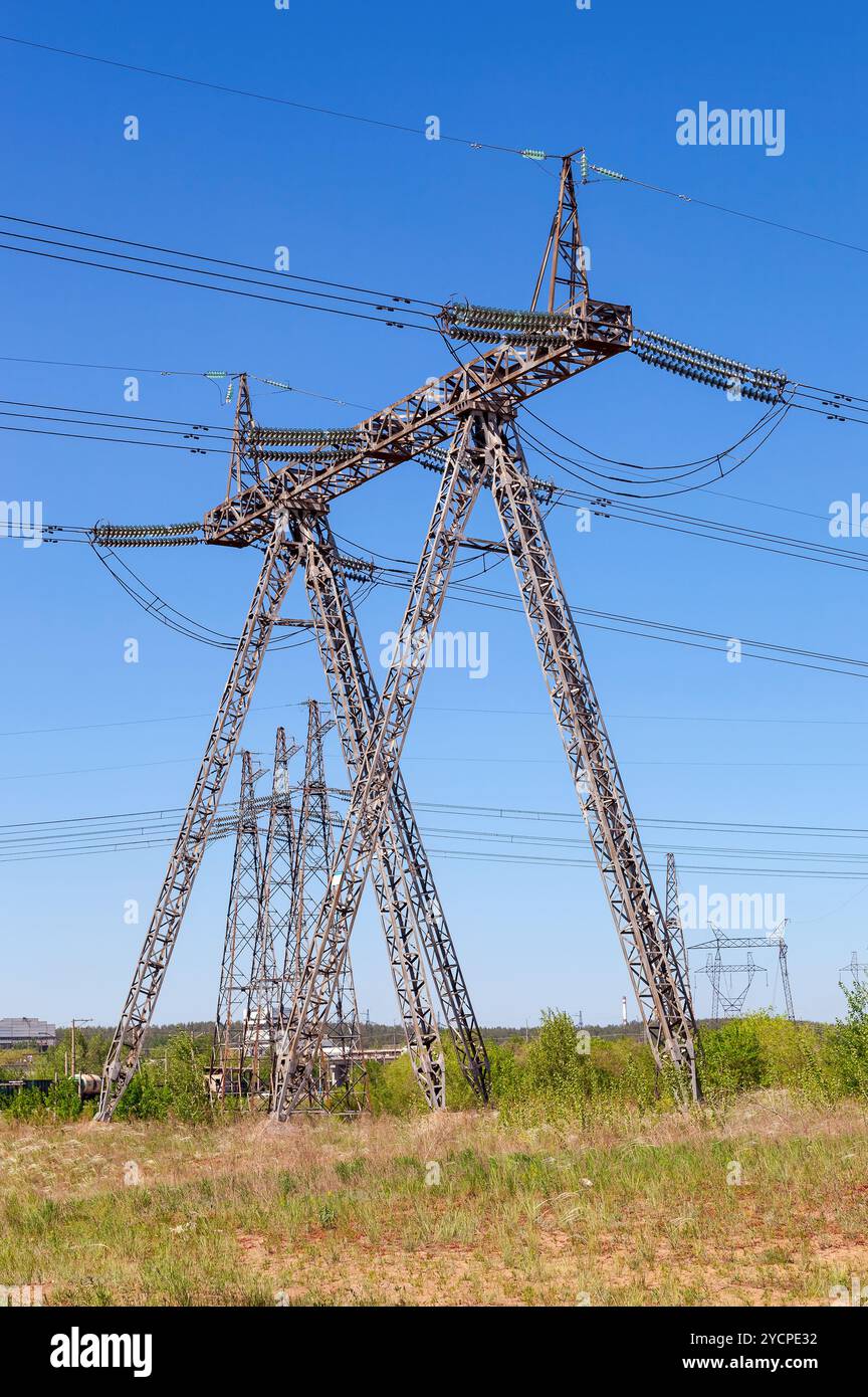 Standardenergie obenliegende Linie Sendemast gegen blauen Himmel Stockfoto