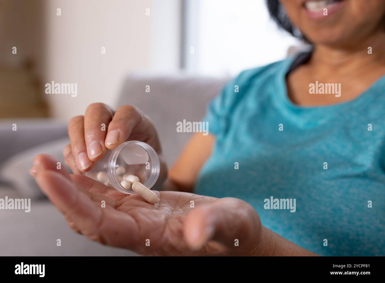 Asiatische Seniorin nimmt Medikamente zu Hause, Schwerpunkt Gesundheit und Wellness Stockfoto