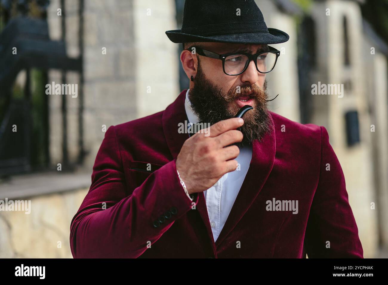 Reicher Mann in einer Jacke in der Nähe seines Hauses Stockfoto