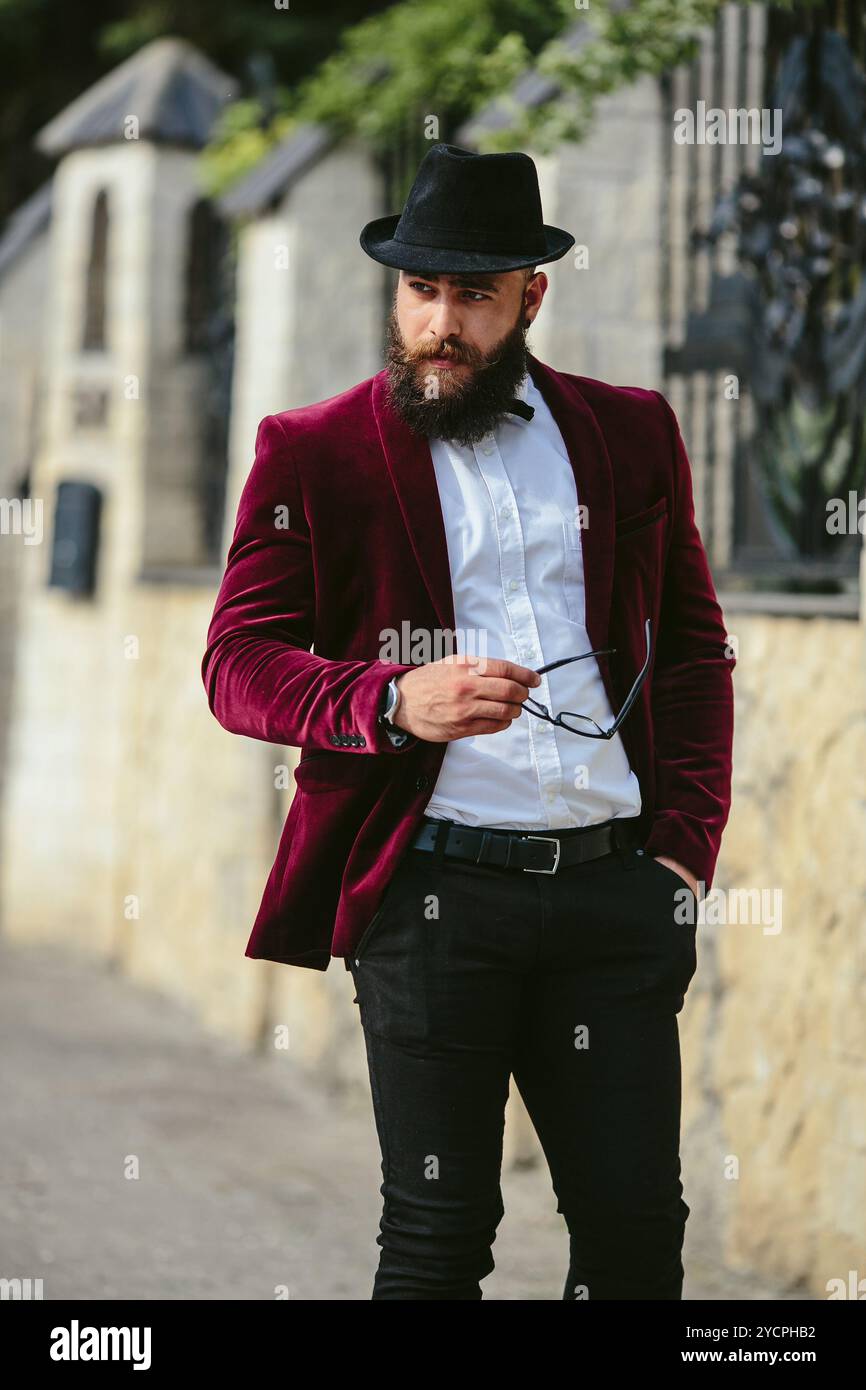 Reicher Mann in einer Jacke in der Nähe seines Hauses Stockfoto