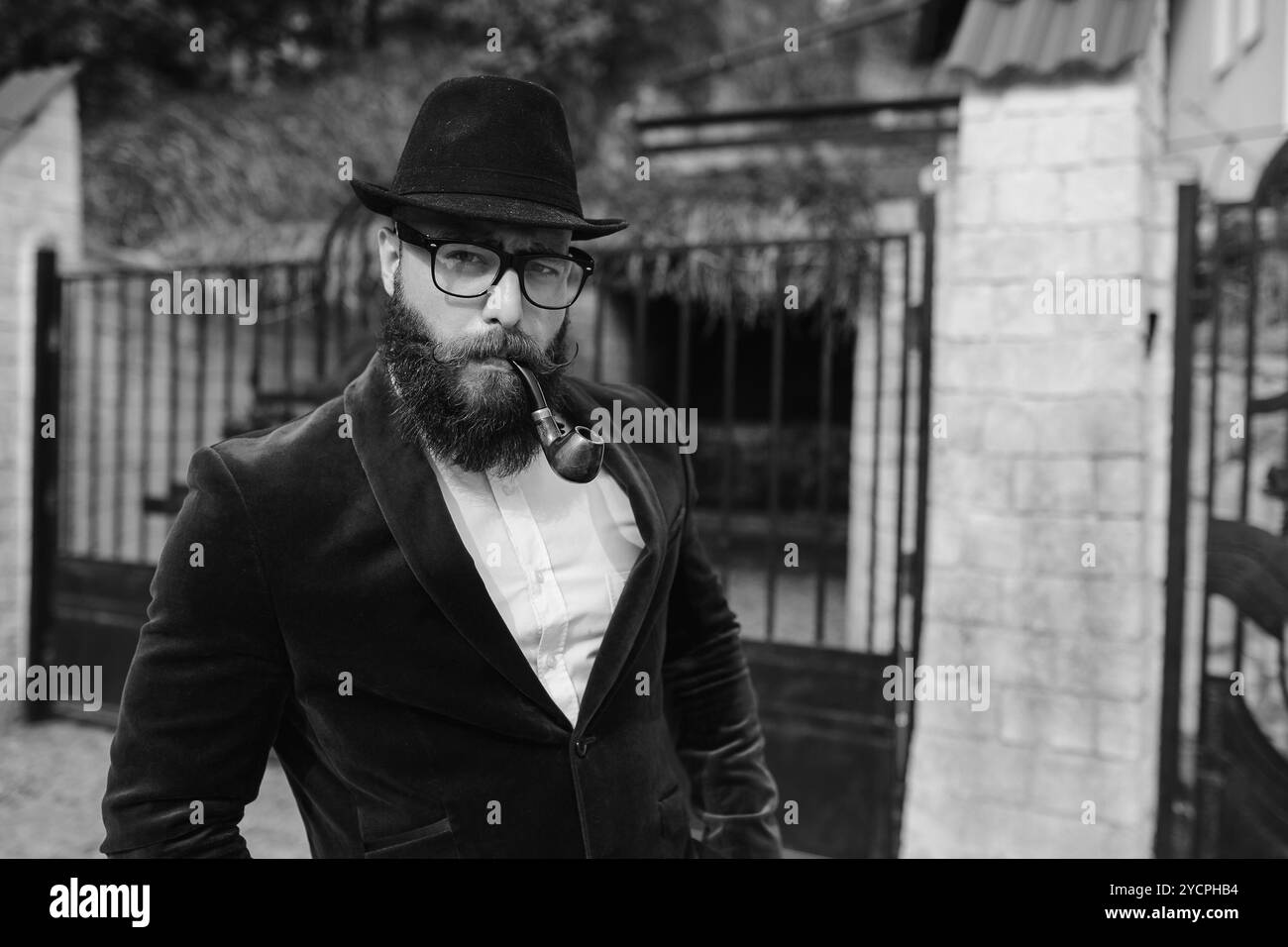 Reicher Mann in einer Jacke in der Nähe seines Hauses Stockfoto