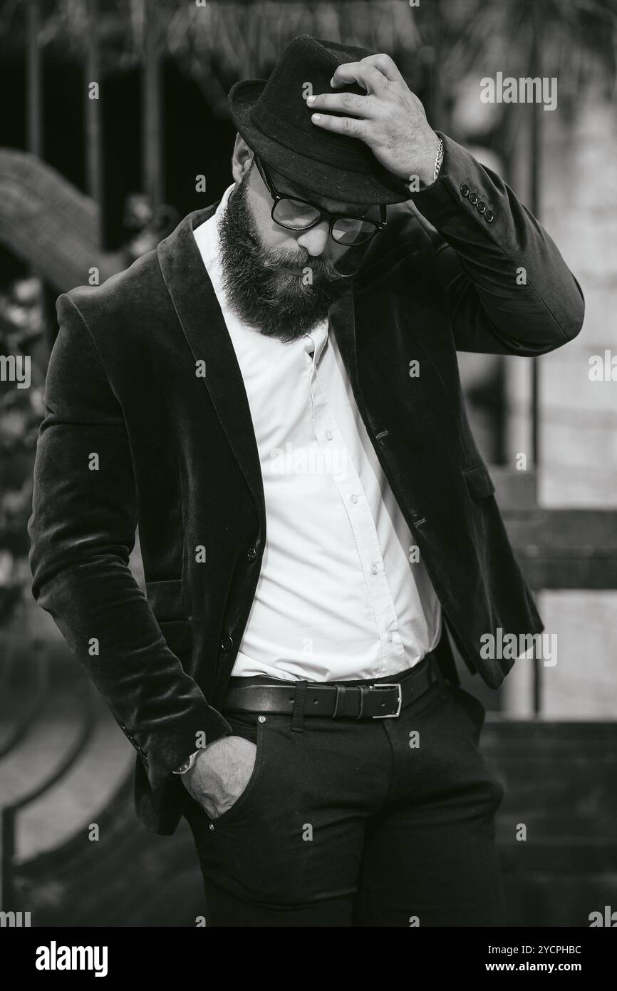 Reicher Mann in einer Jacke in der Nähe seines Hauses Stockfoto