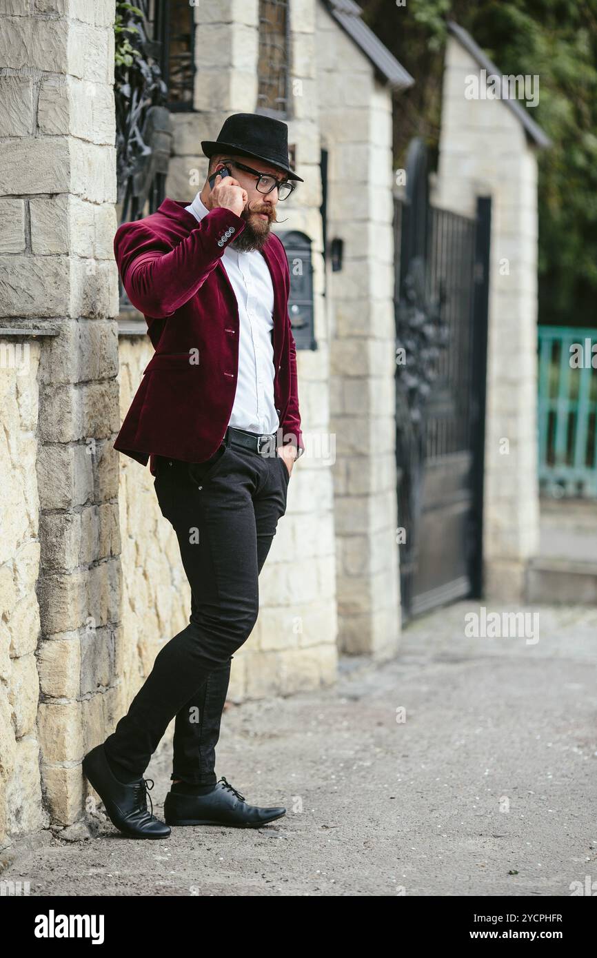 Reicher Mann in einer Jacke in der Nähe seines Hauses Stockfoto