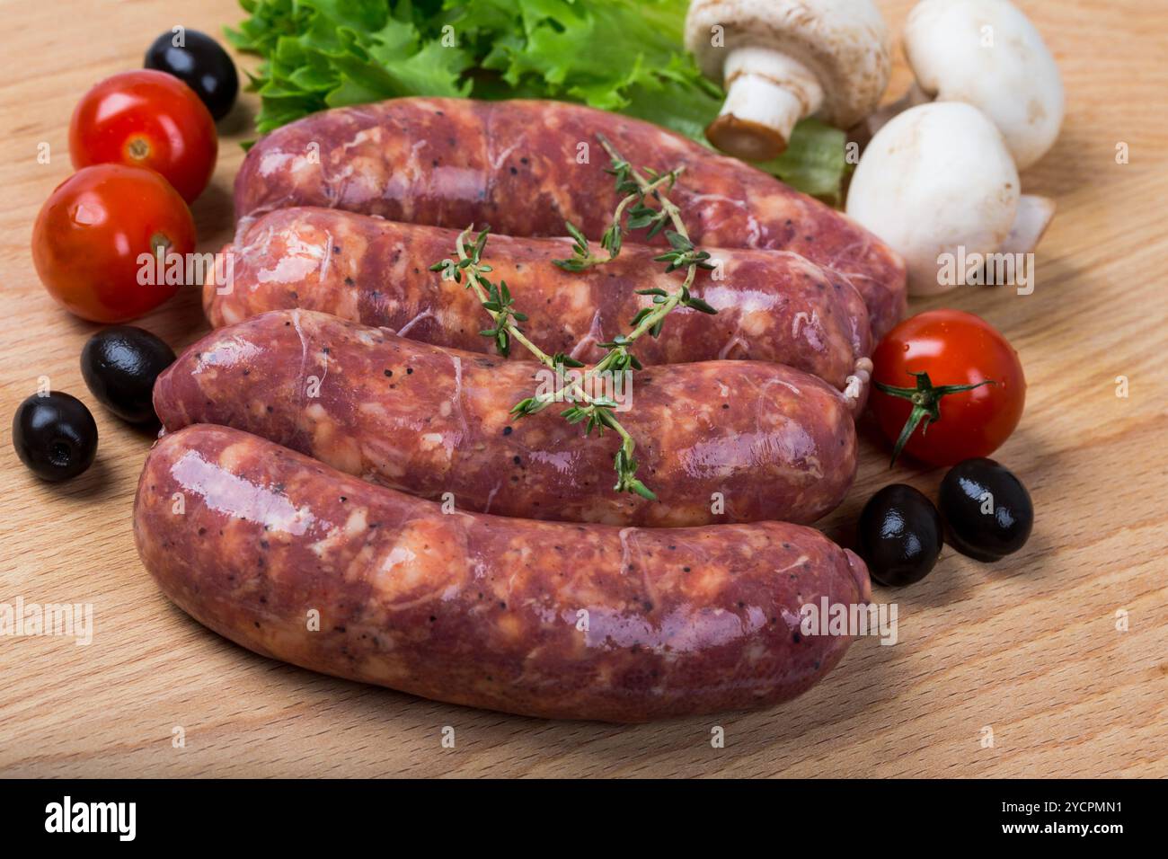 Rohe Würstchen auf Holzbrett Stockfoto