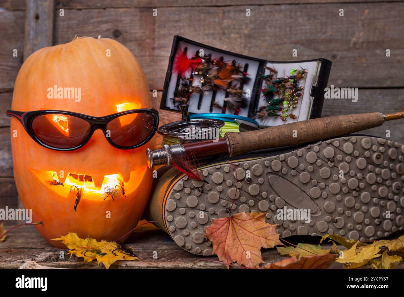 Halloween Kürbis mit Watstiefeln und Fliegenfischen Stockfoto