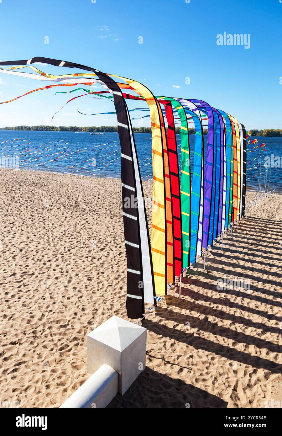 Festliche bunte Fahnen am Ufer des Flusses an einem sonnigen Tag Stockfoto